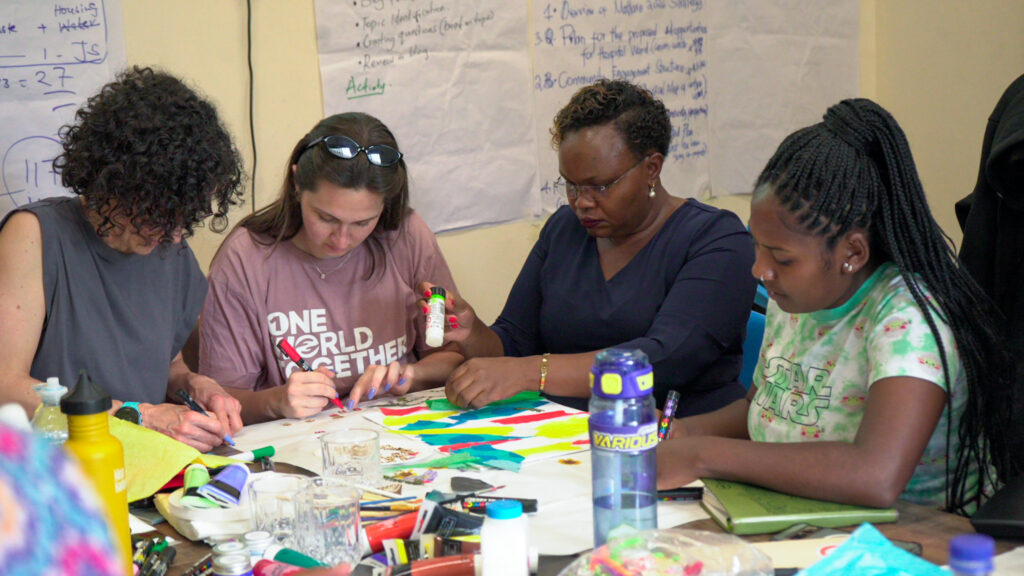 Four women deep in concentration surrounded by arts and crafts.