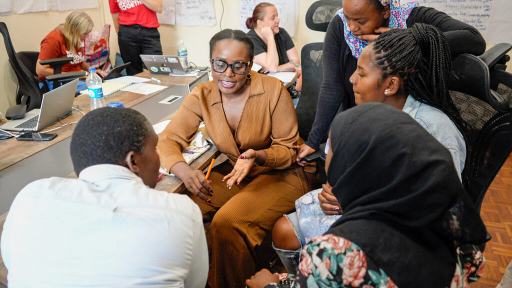 A moment of reflection during our first day together. A smartly-dresed woman deep in conversation with colleagues.